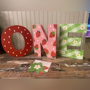 One strawberry birthday photo prop. New in box, box is beat up from shipping.